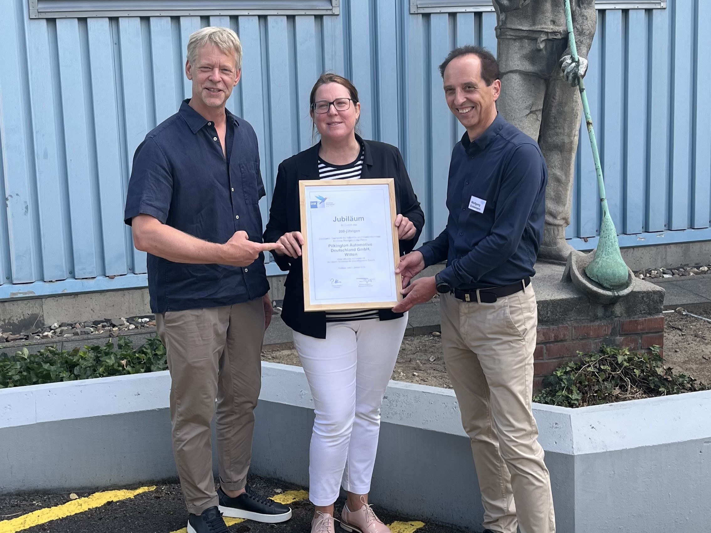 Wittens Bürgermeister Lars König mit Dr. Katja Fox von der IHK Mittleres Ruhrgebiet, die Wolfgang Endemann, Geschäftsführer der Pilkington Automotive Deutschland GmbH, die Urkunde zur 200-jährigen IHK-Mitgliedschaft überreicht (v.l.n.r.).